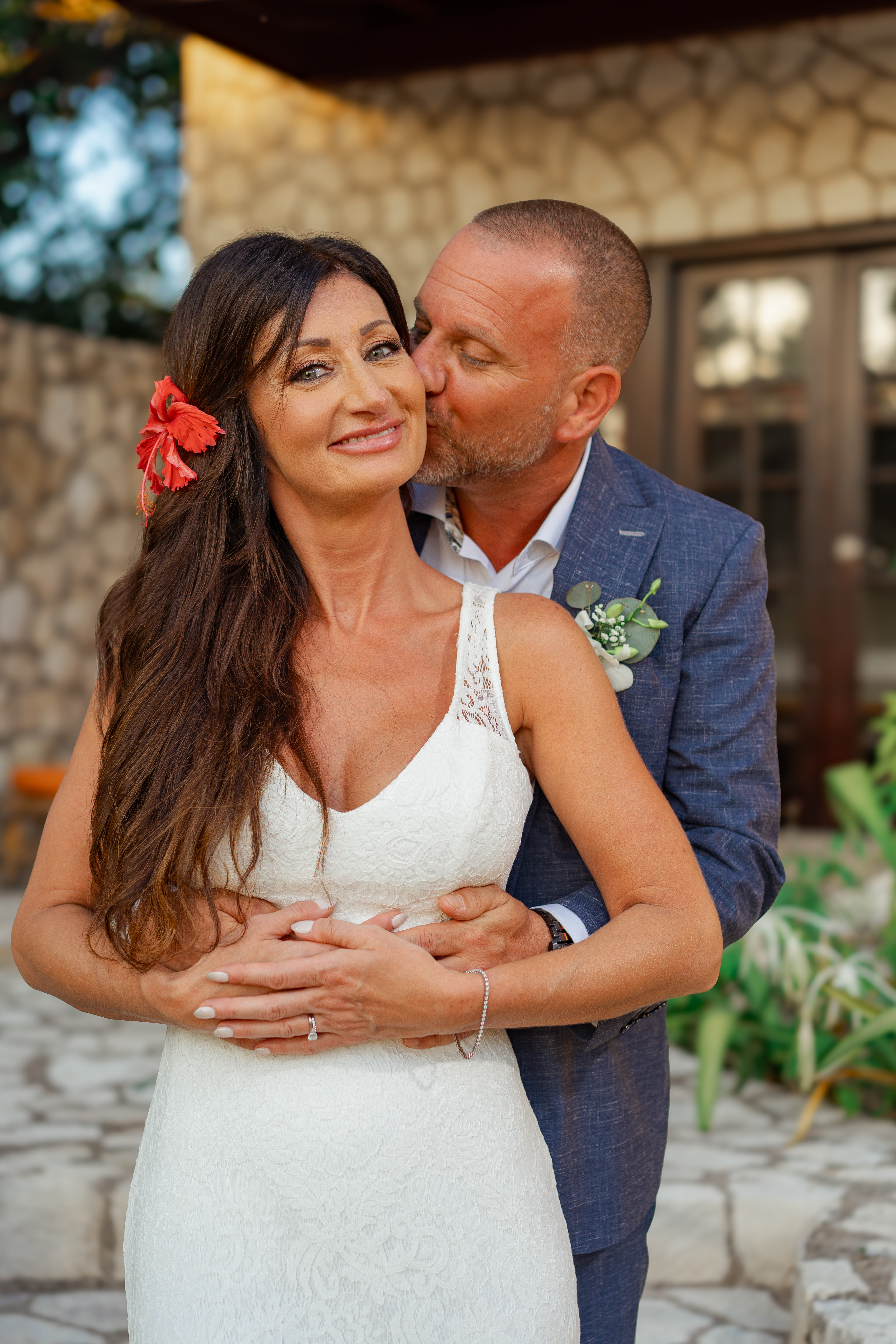 Sarah glowing as Joe kisses her cheek, close portrait