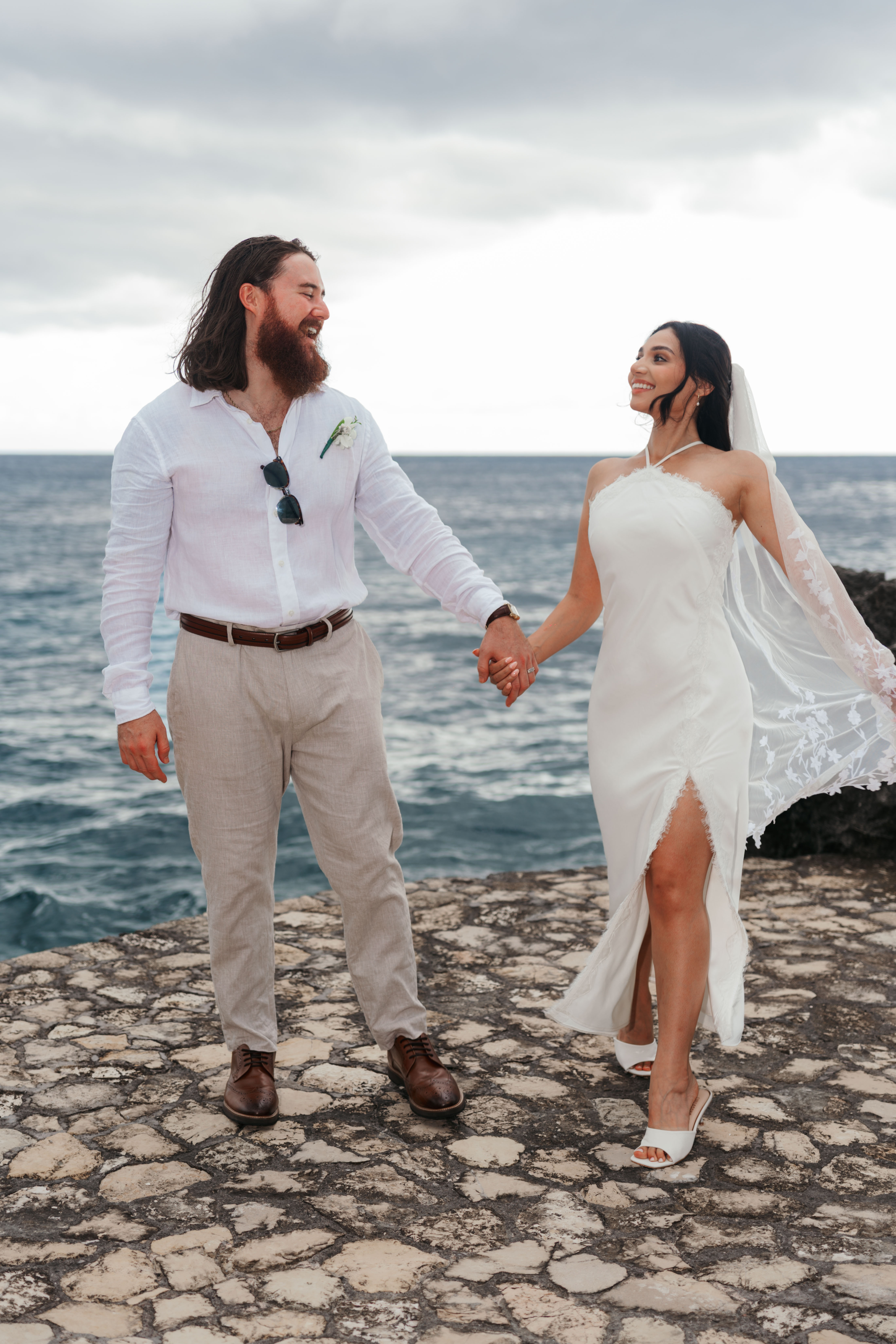 Dylan and Daliah walking hand in hand by the sea in Negril