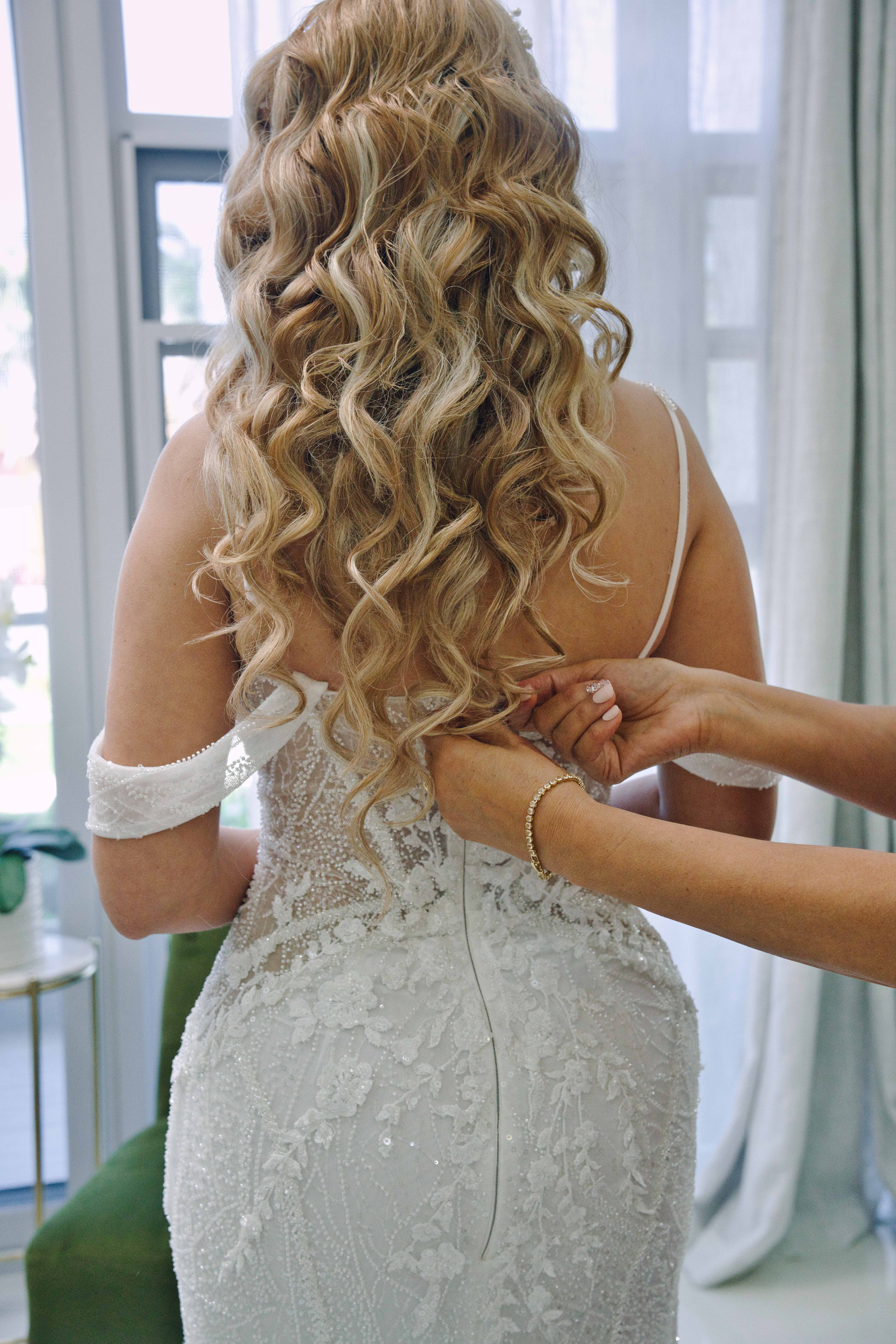 Debra getting her dress buttoned up, curls cascading down her back